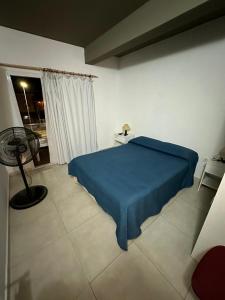 a bedroom with a blue bed and a window at Hospedaje Familia Puma in Valeria del Mar