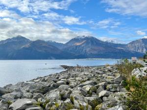 a rocky shore of a lake with mountains in the background at Murphy's Alaskan Inn in Seward