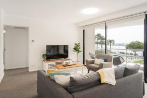 a living room with a couch and two chairs and a tv at Riverside Retreat! Beautiful Water Views! - New Farm in Brisbane
