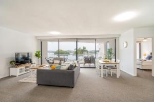 a living room with a couch and a table at Stylish Riverside Retreat - New Farm in Brisbane