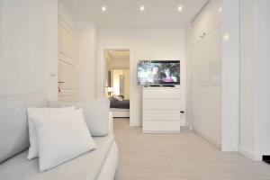 a white living room with a couch and a tv at Luxury Apartment Of Split in Split