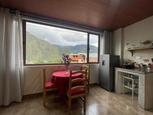 eine Küche mit einem Tisch und einem großen Fenster in der Unterkunft Pine Hill apartment 1 bedroom 1 bathroom in Baños