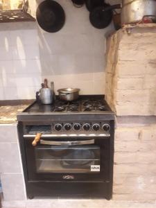 a stove in a kitchen with pots and pans at Casa de adobe Cuesta blanca in Cordoba