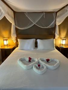 uma cama com duas almofadas em forma de coração em Pousada Santo Mar em Arraial d'Ajuda