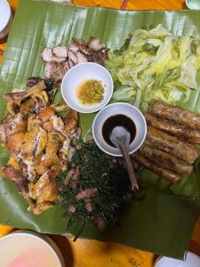 a plate of food with meat and vegetables on a banana leaf at Happy Family Hotel in Sa Pa