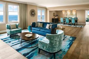 a living room with a blue couch and chairs at The Ritz-Carlton, Half Moon Bay in Half Moon Bay
