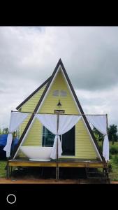 a small yellow house with a white canopy at สวนเบอร์รีแคมป์ทนายจุฬา Berry Camp Korat in Ban Nong Khon