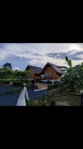 een huis in het midden van een tuin met een huis bij สวนเบอร์รีแคมป์ทนายจุฬา Berry Camp Korat in Ban Nong Khon