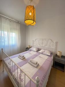 a bedroom with a white bed with a purple comforter at Apartments with parking space Privlaka, Zadar - 21749 in Privlaka