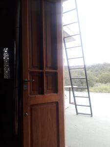 a wooden door with a ladder in front of a window at Casa de adobe Cuesta blanca in Cordoba