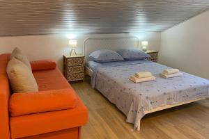 a bedroom with a bed and an orange couch at Apartments with parking space Privlaka, Zadar - 21749 in Privlaka
