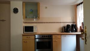 a kitchen with a stove and a microwave at Apartement Victoria in Swisttal