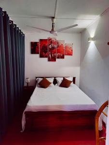 コロンボにあるAraliya Uyana Residencies Colombo - Entire House with Two Bedroomsのベッドルーム1室(壁に絵画3点が飾られたベッド1台付)