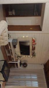 ein Bad mit einer Treppe und einem TV an der Wand in der Unterkunft Aconchegante casinha de madeira in Itapema