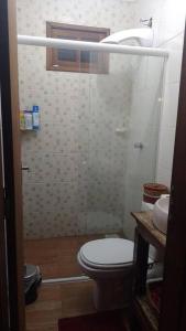 ein Bad mit einem WC und einem Waschbecken in der Unterkunft Aconchegante casinha de madeira in Itapema