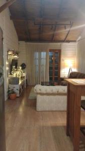 ein Wohnzimmer mit einem Sofa und einem Spiegel in der Unterkunft Aconchegante casinha de madeira in Itapema