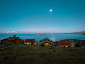 Ecolodge K'arasirca في Comunidad Yumani: منزل على تلة مع القمر في السماء