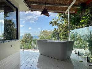 a bath tub in a room with a large window at Tantawan sea view residence 山海居 in Salad Beach