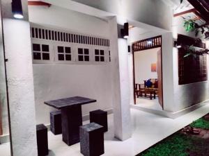 コロンボにあるAraliya Uyana Residencies Colombo - Entire House with Two Bedroomsの家の中のテーブルとスツール付きの部屋