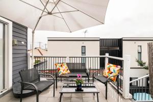 a balcony with chairs and a table and an umbrella at Urban Elegance apartment in Yarraville village in Yarraville