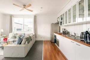 a living room with a couch and a kitchen at Urban Elegance apartment in Yarraville village in Yarraville
