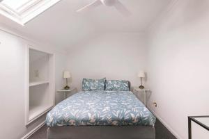 a bedroom with a bed in a white room at Urban Elegance apartment in Yarraville village in Yarraville