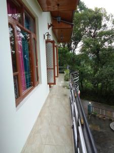 a balcony of a house with windows and a porch at Samaira home stay in Bīr