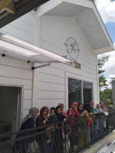 eine Gruppe von Frauen, die auf dem Balkon eines Gebäudes stehen in der Unterkunft Resy home syariah dekat alun2 wonosobo in Kalianget
