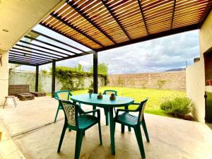 un patio con mesa y sillas bajo toldo en Vista Montaña en Mendoza