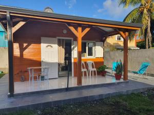 Casa con patio con mesa y sillas en Bungalow vacances en Sainte-Rose