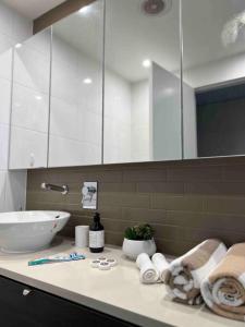 baño con lavabo y encimera con toallas en Sea Pearl Apartment at Waterfront, en Darwin