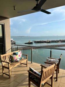 2 bancos en un balcón con vistas al océano en Sea Pearl Apartment at Waterfront, en Darwin
