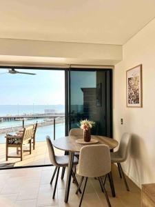 ein Esszimmer mit einem Tisch und Meerblick in der Unterkunft Sea Pearl Apartment at Waterfront in Darwin