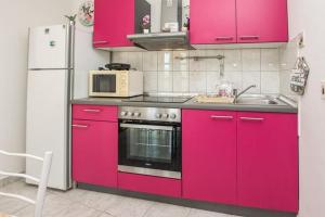 cocina rosa con fregadero y microondas en Apartments by the sea Bibinje, Zadar - 22075, en Bibinje