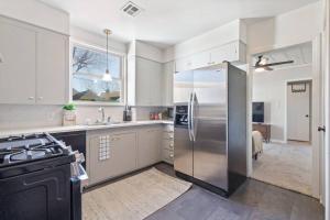 a large kitchen with a stainless steel refrigerator at Vintage Chic Cottage in Tulsa