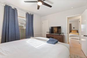 a bedroom with a white bed and a ceiling fan at Vintage Chic Cottage in Tulsa