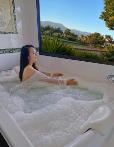 a woman is sitting in a bath tub at Pool Villa Kiang Na Mae Rim in Mae Rim