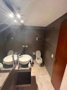 a bathroom with a toilet and a sink and a mirror at DEPARTAMENTO EN GUEMES CORDOBA in Córdoba