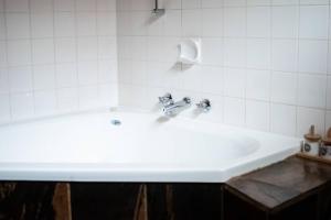 a white sink in a white tiled bathroom at Avon River Inn in Stratford