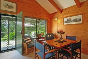 comedor de madera con mesa y sillas de madera en Blue Gums Cottage, en Valle Kangaroo