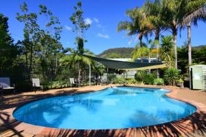 una piscina con una hamaca en un patio en Blue Gums Cottage, en Valle Kangaroo