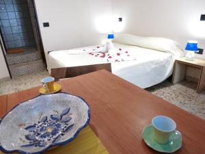 カリアリにあるCagliari Centroのベッド1台、テーブル(2杯付)が備わる客室です。