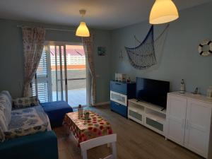 a living room with a bed and a television at Apartamento en Tenerife- Candelaria Islas Canarias in Candelaria