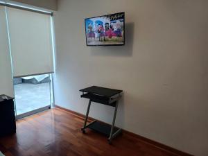 una habitación con una mesa y una foto en la pared en Habitación acogedora Aramburú, en Lima