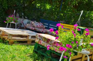 a bench and a table with flowers in a yard at Mostar Downtown Hostel in Mostar