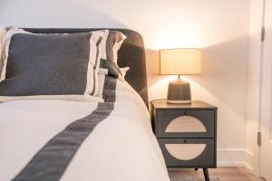 a bedroom with a bed and a nightstand with a lamp at Stylish One Bedroom Retreat, Downtown Victoria, Fitness Room, Incredible Location! in Victoria