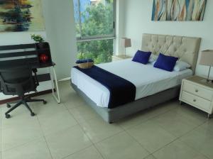 a bedroom with a bed and a desk and a computer at Ecusuites Resort Riverfront Family Dept Santa Ana Gye in Guayaquil