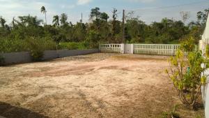 a yard with a white fence and a dirt field at Casa em Itapoá o Paraiso - Wifi - Ótimo Preço - Promoções in Itapoa