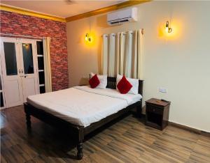 a bedroom with a bed with red pillows on it at Hotel Romeo's Place Near Baga Beach - 50 meters from Baga Beach in Baga