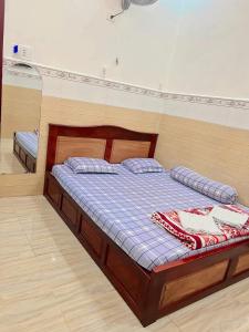 a bed with two pillows on it in a room at Nhà nghỉ phương nam in Ấp Rạch Mẹo